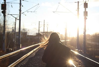 Woman walking on railroad tracks