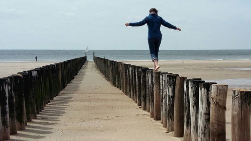 Full length of man standing on beach against sky