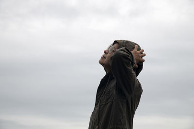 Low angle view of person looking away against sky