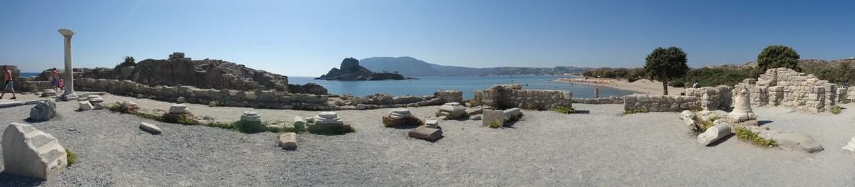 Panoramic view of calm beach against clear blue sky