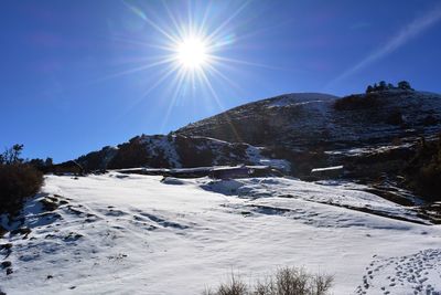 Scenic view of snowcapped mountains against sky on sunny day