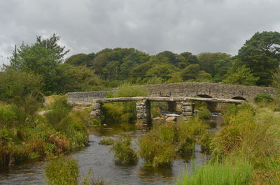 Arch bridge over river against sky