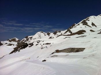 Scenic view of snowcapped mountains against blue sky