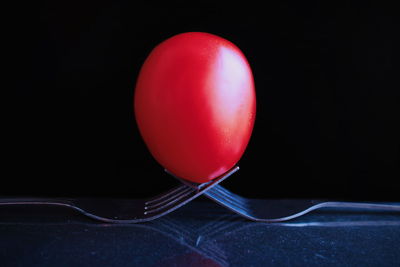 Close-up of red balloons on table against black background