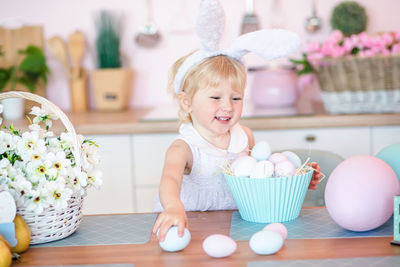 Portrait of cute baby girl sitting on table