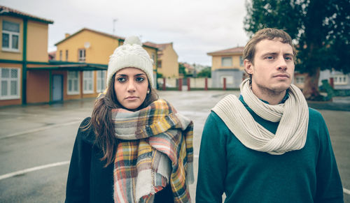 Sad couple looking away while standing on road