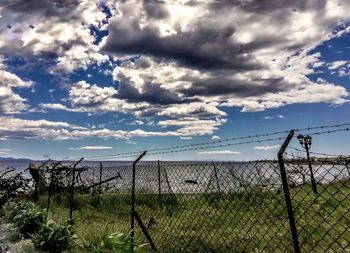 Fence on field against sky