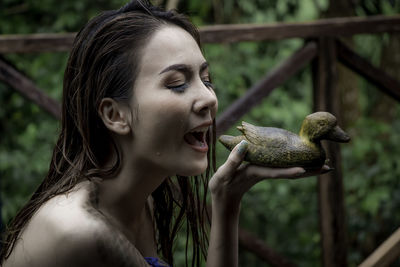 Portrait of young woman holding bird