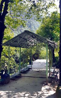 Gazebo in forest against sky