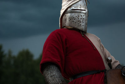Low angle view of man wearing armored clothing against sky