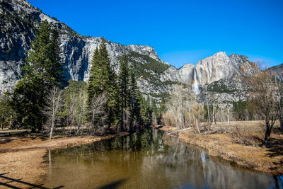 Scenic view of lake and mountains against blue sky