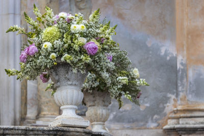 Romantic wedding bouquet in a baroque stone vase in taormina in sicily in italy