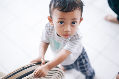 Cute boy looking at camera at home