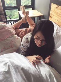 High angle view of woman lying on bed