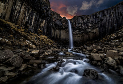 Scenic view of waterfall against sky