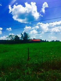 Scenic view of grassy field against cloudy sky