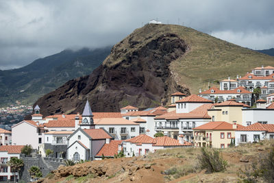 Town by mountain against sky
