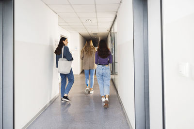 Rear view of people walking in corridor