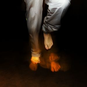 Low section of man standing against black background