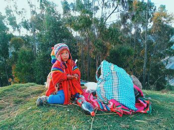 Full length of girl sitting on tree during winter