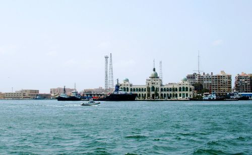Ship in sea with city in background