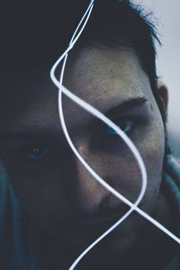 Close-up portrait of man holding string light