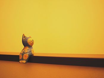 Close-up of toy on table against yellow background