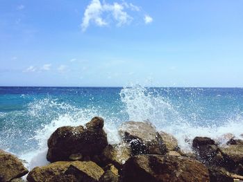 Close-up of waves splashing on shore against sky