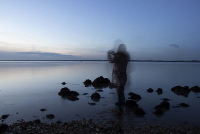 Figure of a woman with motion blur by the sea
