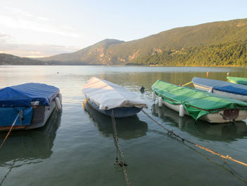 Boats moored in lake against sky