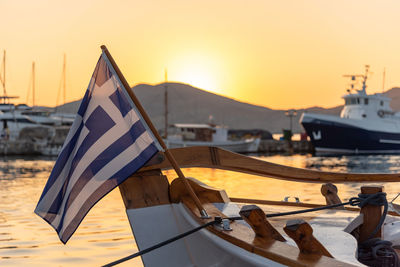 Boats moored at harbor against sky during sunset