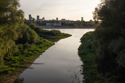 River amidst buildings in city against sky