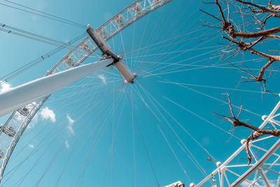 Low angle view of millennium wheel against blue sky in city