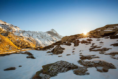 Scenic view of snowcapped mountains against clear sky during winter