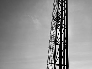 Low angle view of silhouette crane against sky