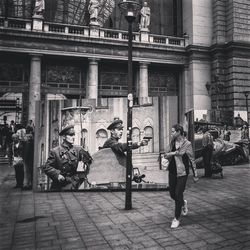 People on street against buildings in city