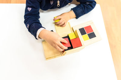 High angle view of boy holding umbrella on table at home