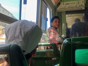 Full length of woman sitting in train