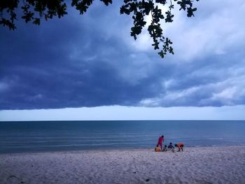 People on beach against sky