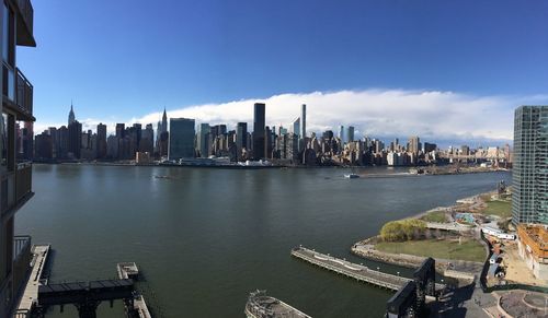 Modern buildings and east river against sky in city