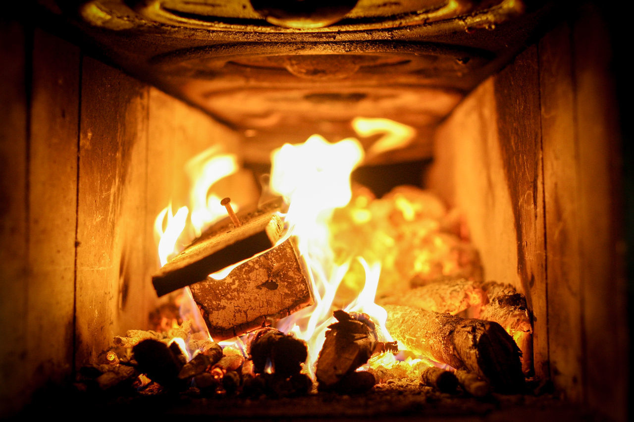 CLOSE-UP OF BURNING CANDLES IN WOOD