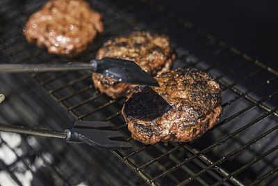 Burger barbecue roasted on metal grill. the person cooking burger