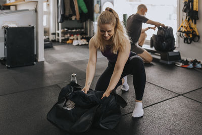 Woman packing equipment after workout in gym