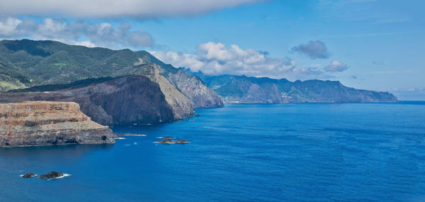 Scenic view of sea and mountains against sky