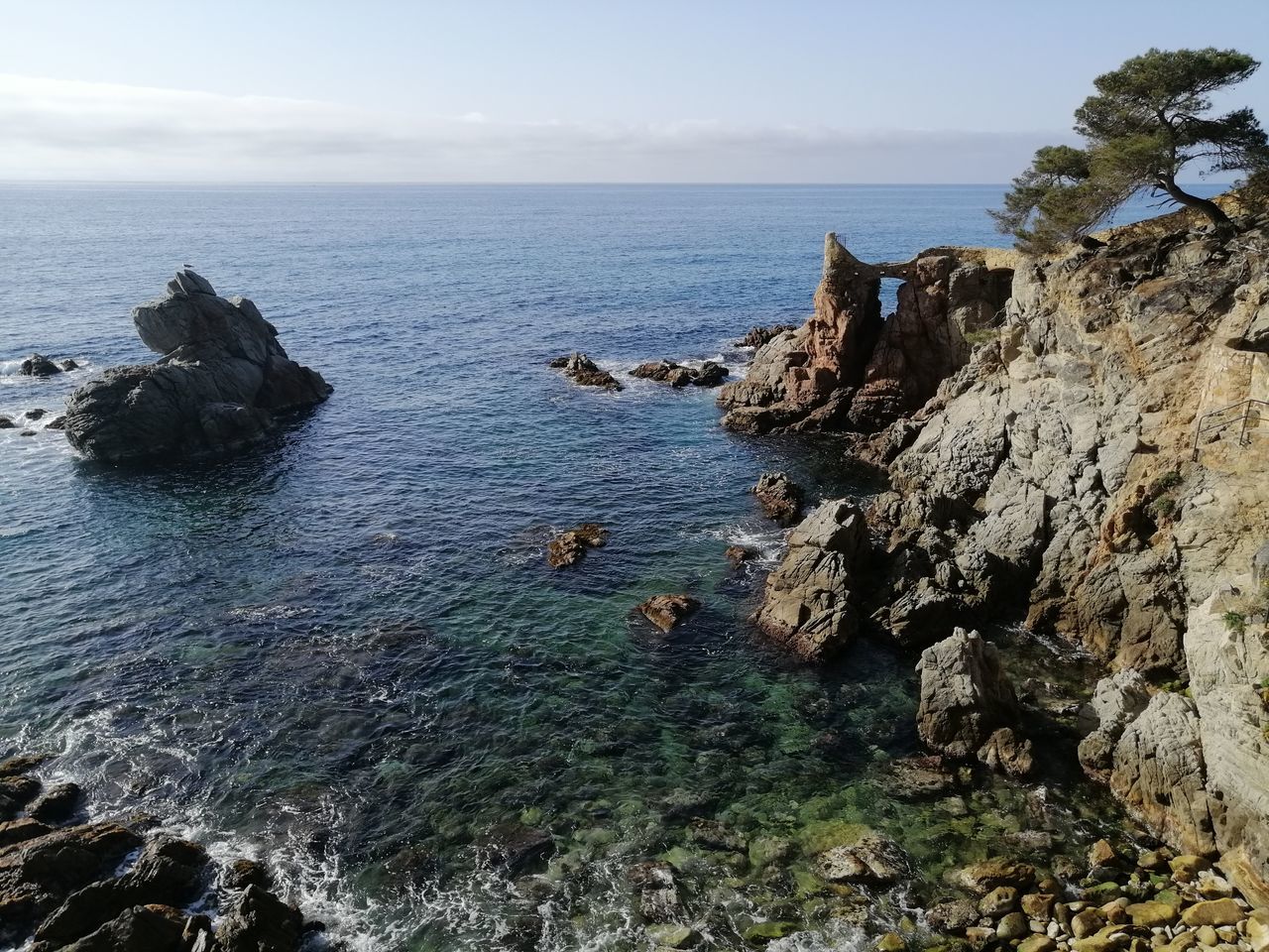 SCENIC VIEW OF ROCKS ON SEA AGAINST SKY