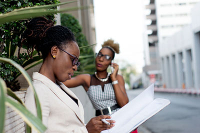 Young businesswoman taking notes and next to her colleague is in communication.