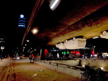 People walking on illuminated road at night