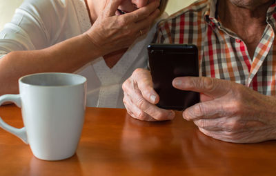 Midsection of man using laptop on table