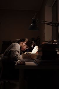 Rear view of woman sitting on table
