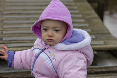 Cute baby girl wearing warm clothing standing outdoors